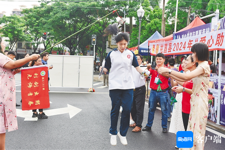 6月7日,在屯昌中学考点,部分家长及老师在考生进场前设置"一举高粽"等