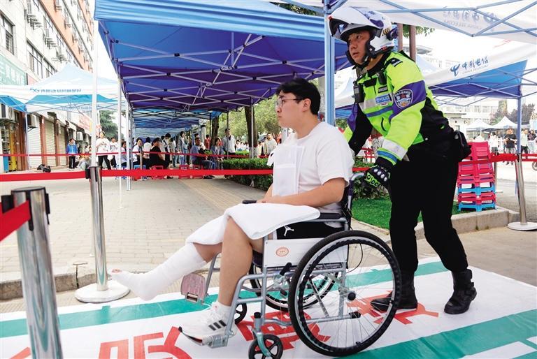 6月7日,渭南市公安局交警支队临渭大队民警护送一名受伤考生进入考场.