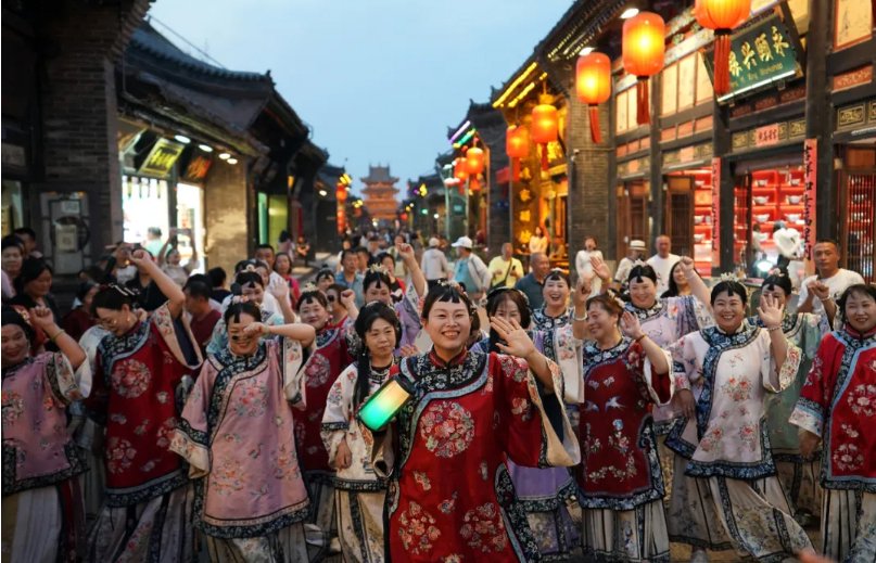 身着传统服装的游客在平遥古城拍照留影(5月14日摄)