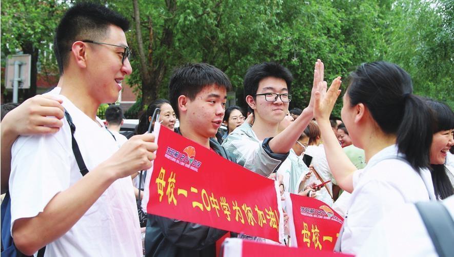 6月7日,沈阳市虹桥中学总校门前,语文考试结束后家长为考生送上鲜花.