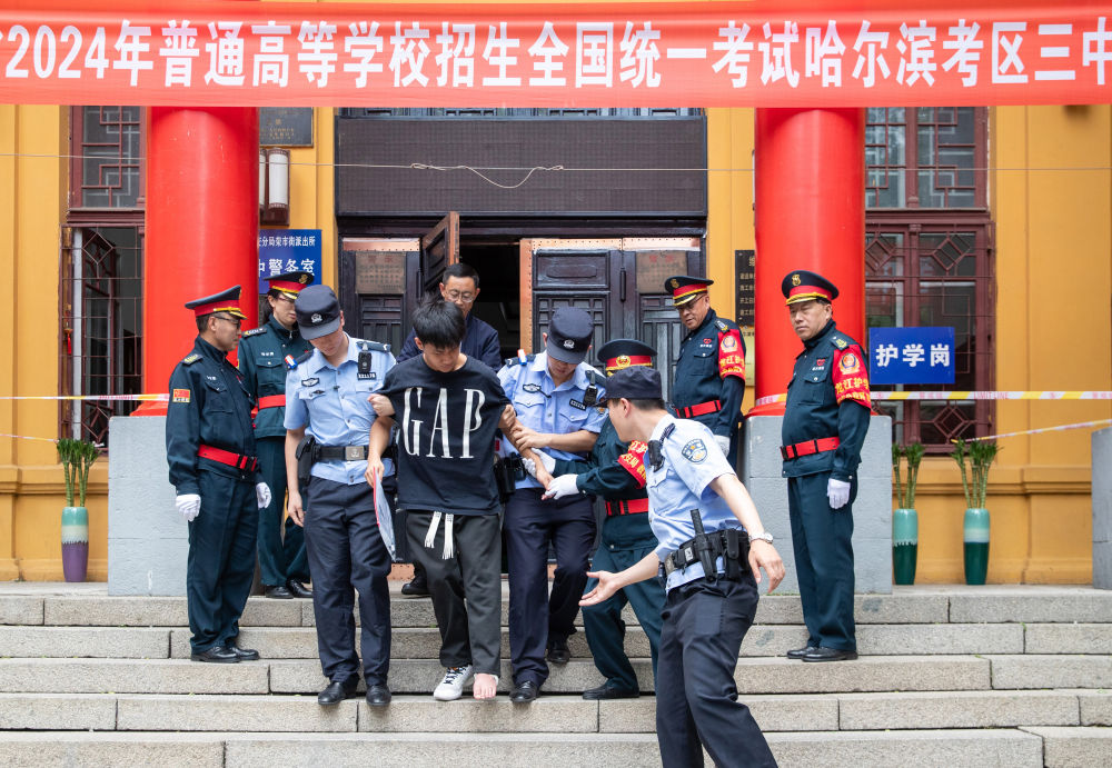 6月7日,在哈尔滨市第三中学考点,一名脚部受伤的考生在工作人员搀扶