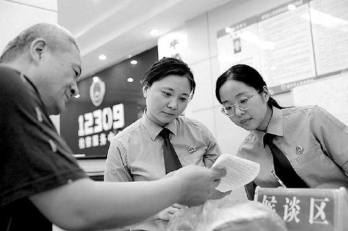 平顶山市湛河区检察院检察官在"安薪"工作室接待来访群众.