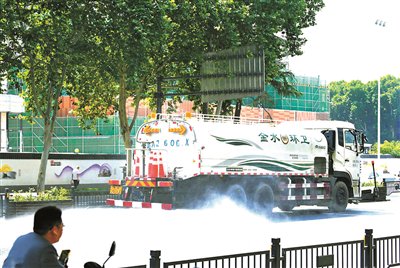 6月11日，洒水车在郑州市金水区花园路洒水降温供图/新华社