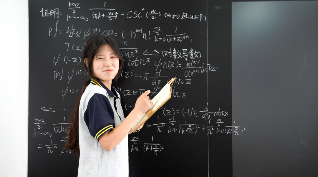 姜萍在黑板上解答数学题。