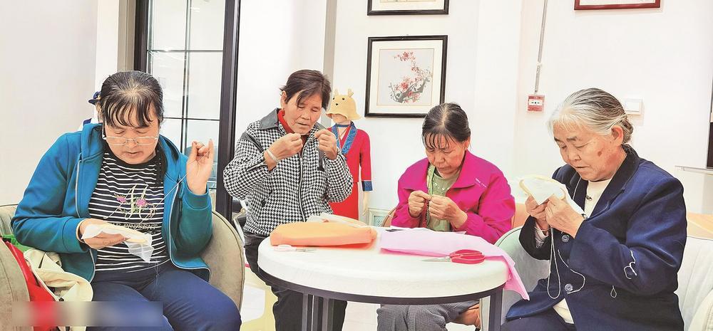 芦花乡易地搬迁安置区东西部协作青绣帮扶车间里,绣娘们制作手工艺品.