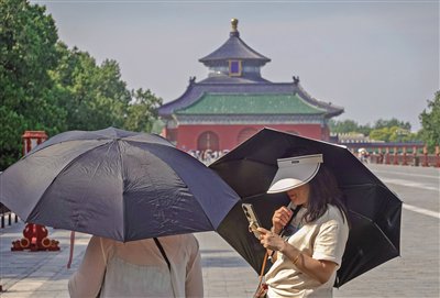 6月17日，天坛公园，遮阳伞和遮阳帽成为游客的必备。新京报记者 李木易 摄