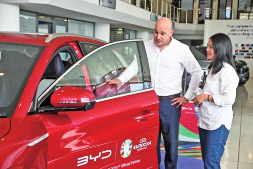      在马耳他比尔基卡拉市，马耳他哈桑-扎米特汽车公司首席执行官德古阿拉（左）正在向客人介绍一辆比亚迪纯电动汽车。新华社
