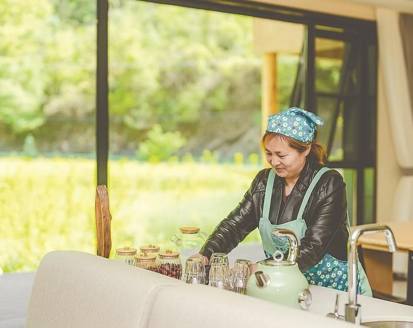 6月14日,隐居乡里·汉水谣民宿服务员张春秀在工作.