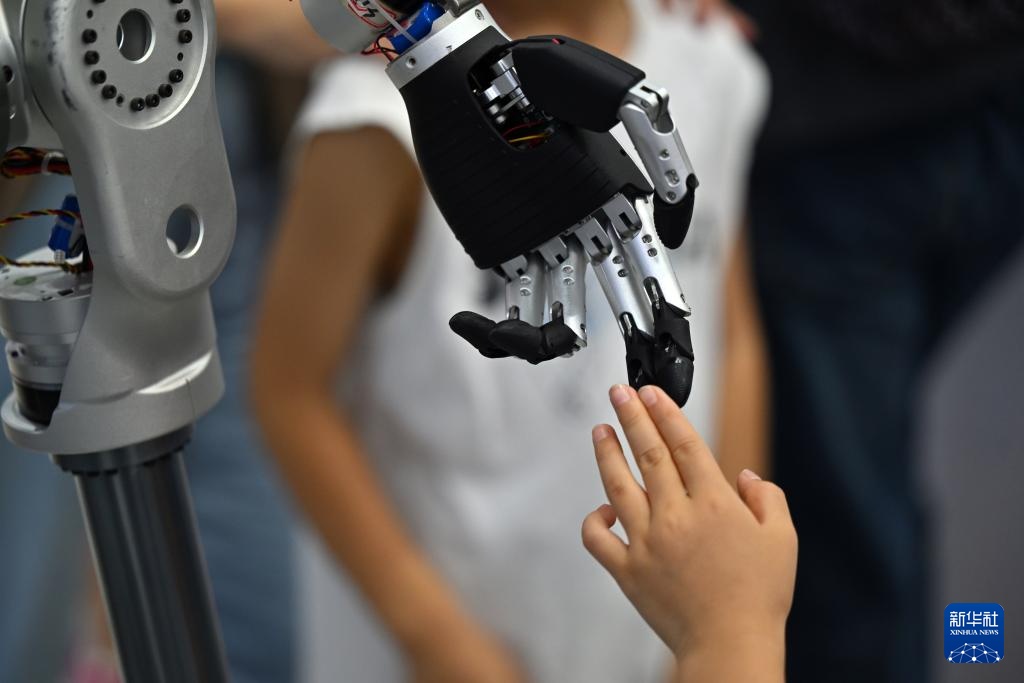 　　6月22日，观众在博览会上触摸人形机器人。