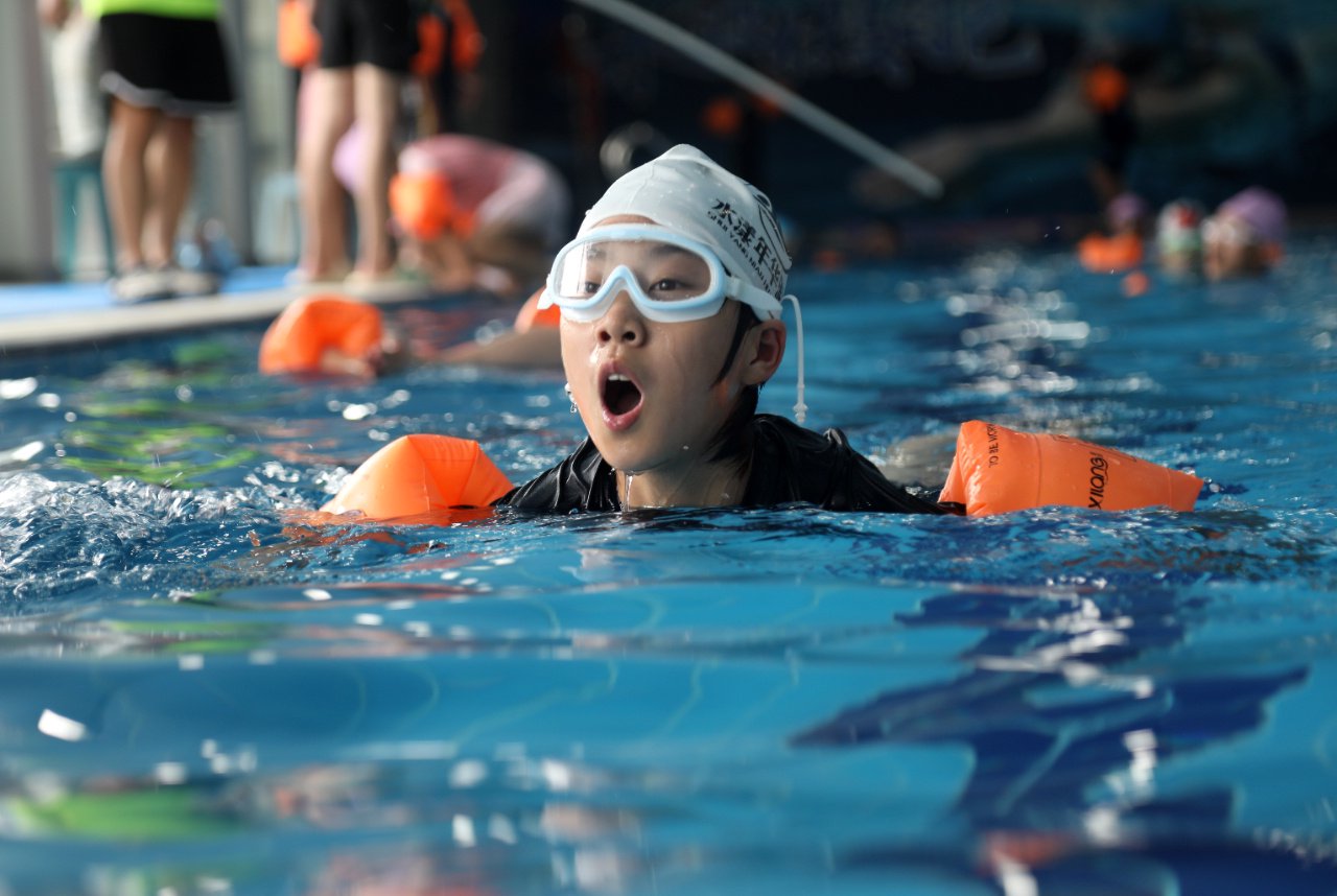 在山东省临沂市郯城县水漾游泳馆内,孩子们在教练的指导下学习游泳