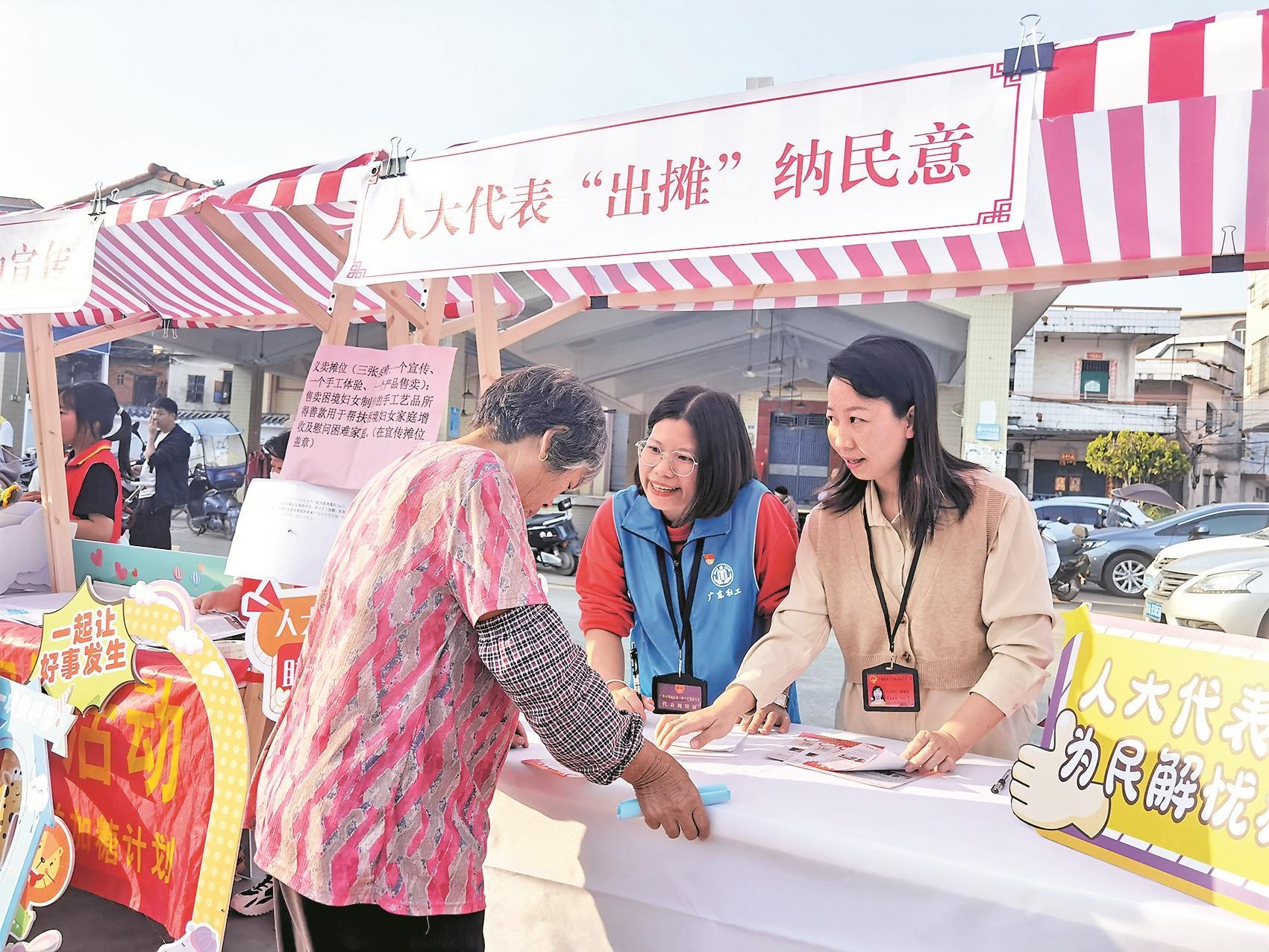 一顶帐篷,一张桌子,一条横幅,一个本子,在广州市增城区朱村街道的集市