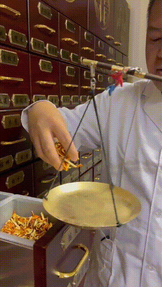 张鹏用戥称称陈皮。中工网记者丁梦茹 摄