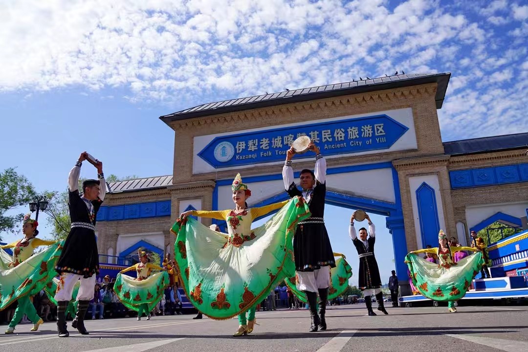 在喀赞其民俗旅游区门口,游客驻足观看具有浓郁民族风情的开街仪式