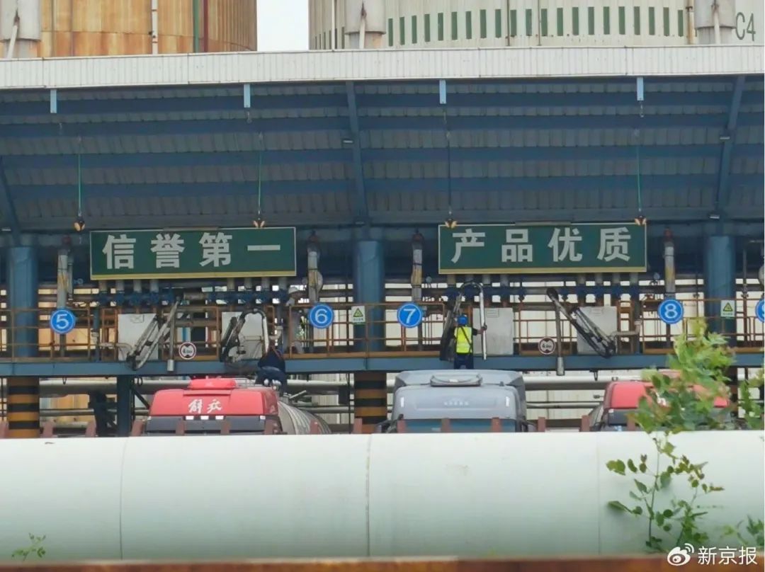5月24日,一辆刚卸完煤制油的罐车,驶入中储粮油脂(天津)有限公司,司机爬上罐顶正准备装运食用油。 新京报记者 韩福涛 摄
