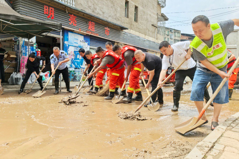7月12日,垫江县永平镇,志愿者正在忙着清除淤泥,清洗杂物,着手灾后