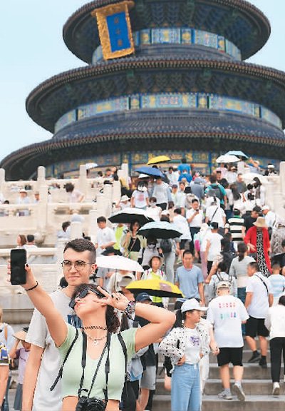 两名外国游客在北京天坛公园祈年殿前自拍合影.新华社记者 鞠焕宗摄