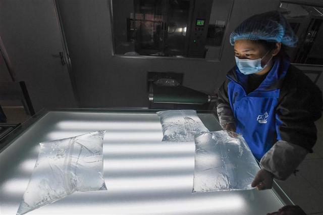 在淳安经济开发区的一家水饮料企业内，工作人员在生产线上检查刚刚生产好的袋装水。 新华社记者 徐昱 摄