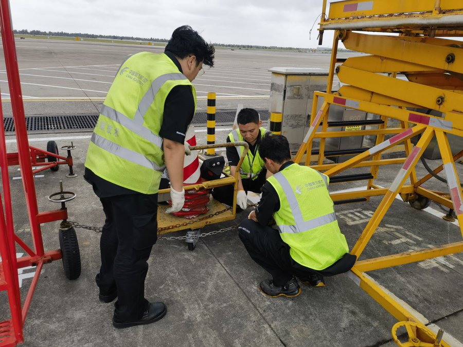 在温州龙湾机场，东航机务工程师在台风到来前夕系留飞机、固定维修拖车