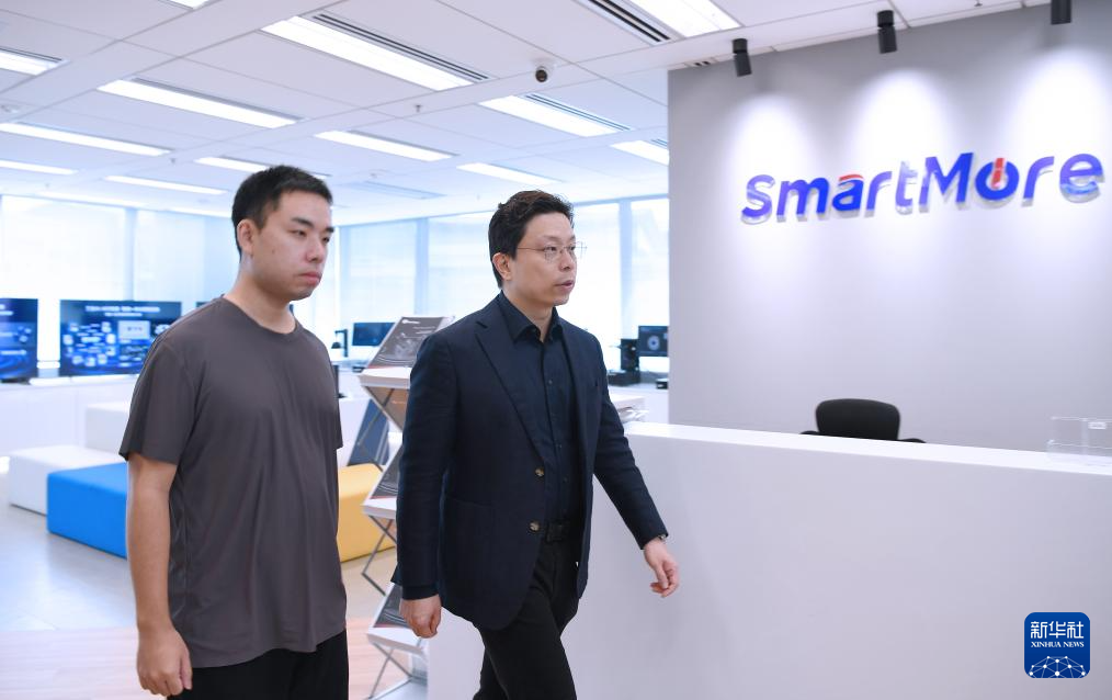 科技创始人兼董事长贾佳亚(右)在位于香港科技园的办公室里和同事交谈