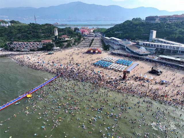 8月3日,大批游客在连云港市连岛景区大沙湾海滨浴场戏水消暑,乐享海边