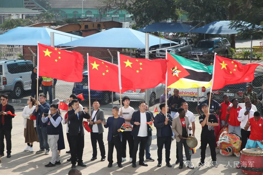 华人华侨挥动中莫两国国旗.