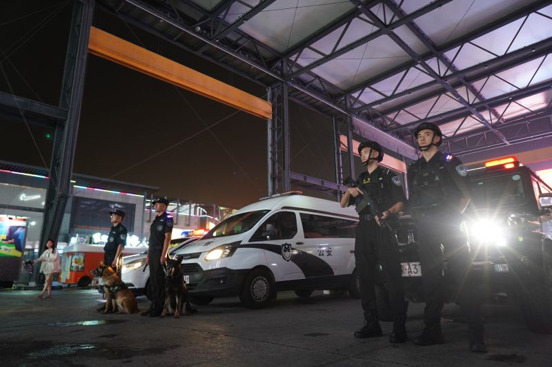 商圈内,一辆黑色特警车旁,有几名特警全副武装值守.