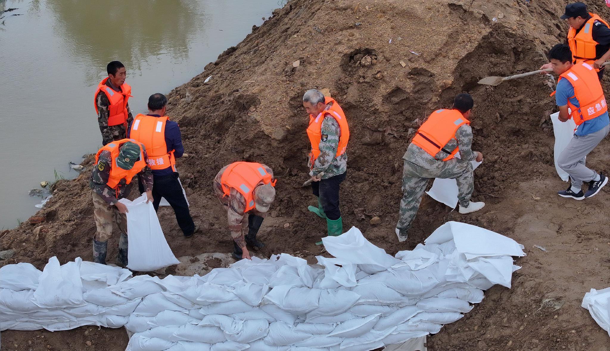 和县水务局的防汛人员组成抗洪突击队,持续作业加固堤坝,装填备用沙袋