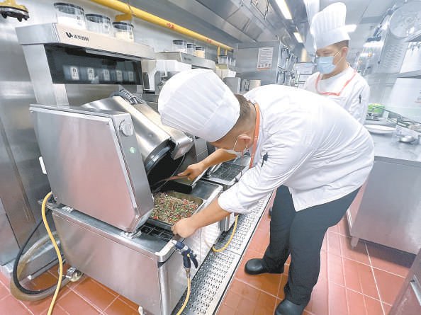 5分钟，炒菜机器人就能炒出一锅热菜。本报记者 马婧 摄