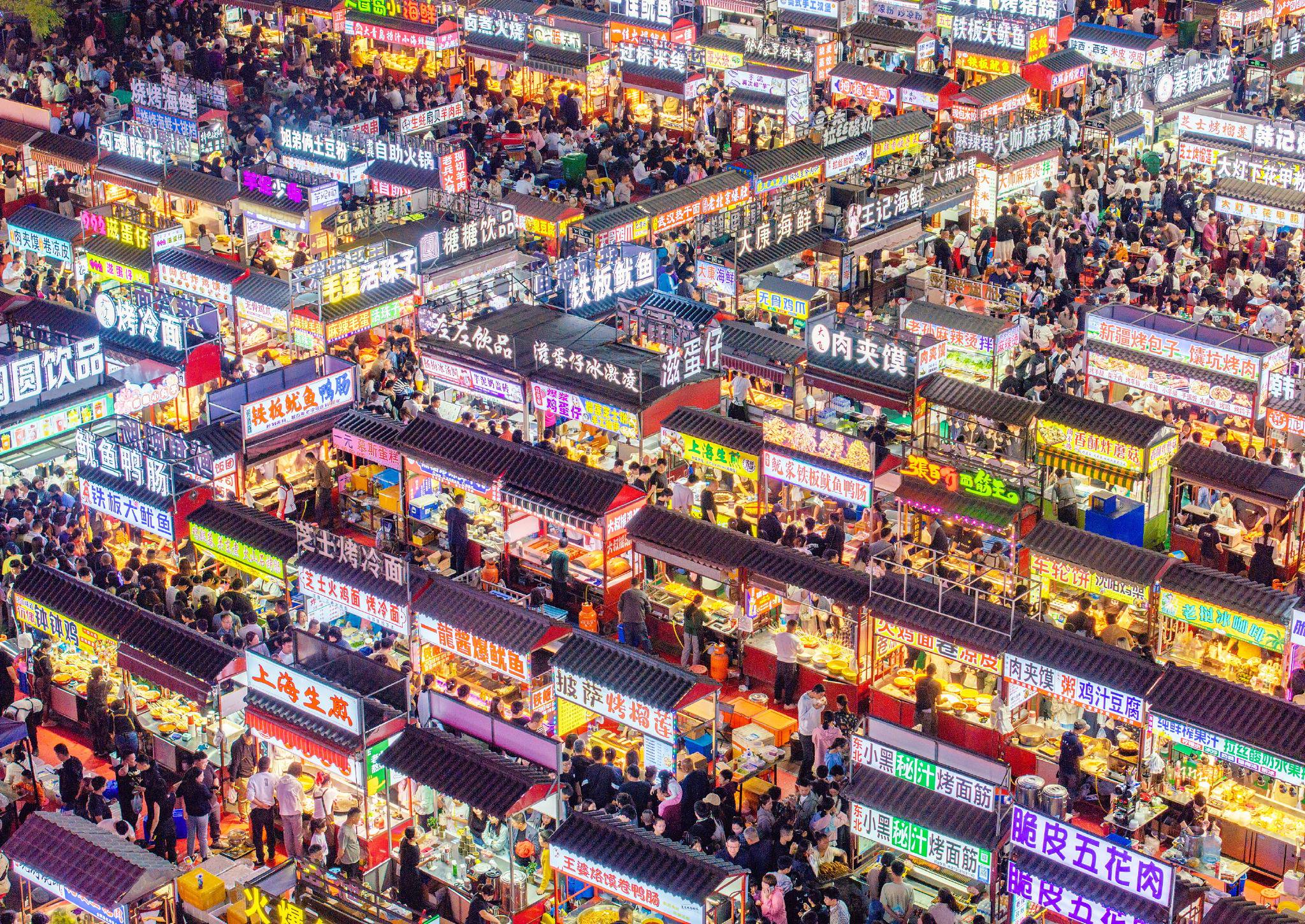 人们在正定小商品夜市品尝美食.武志伟 摄