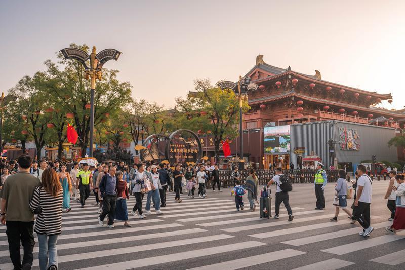 交警和安保人员在大唐不夜城执勤，引导游客过街。