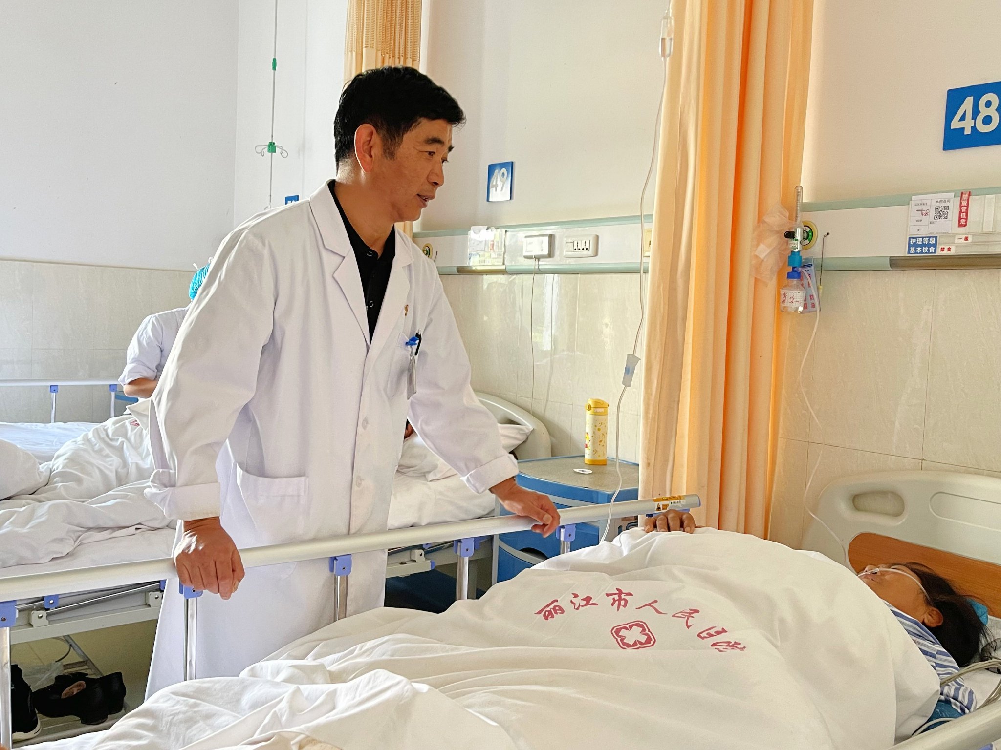 丽江市人民医院外科医生杨承宗与术后病人交流.(徐蕾 摄)