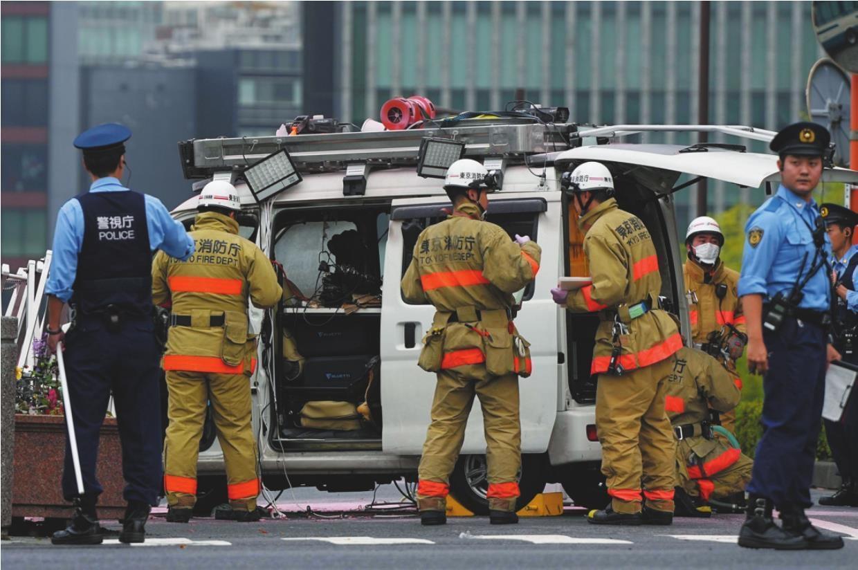 下图:10月19日,在日本东京,警察和消防员在冲撞首相官邸的车辆旁工作.