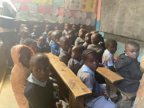 非洲贫困社区学校普遍存在多人共用课桌椅的情况