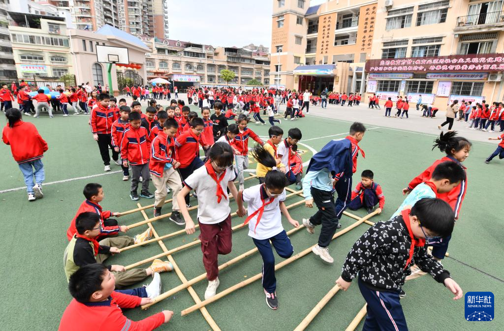 在梧州市新兴二路小学,学生们在体育大课间跳竹竿舞(3月26日摄).