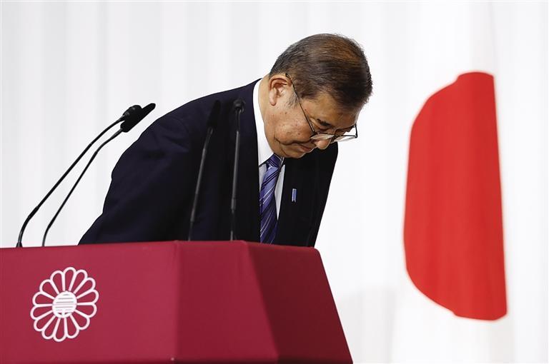 日本首相,自民党总裁石破茂结束在记者会上的讲话后向台上议员鞠躬