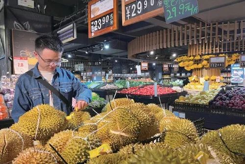 在国内一家超市里，顾客正在选购榴莲。农民日报·中国农网记者 赵倩倩 摄