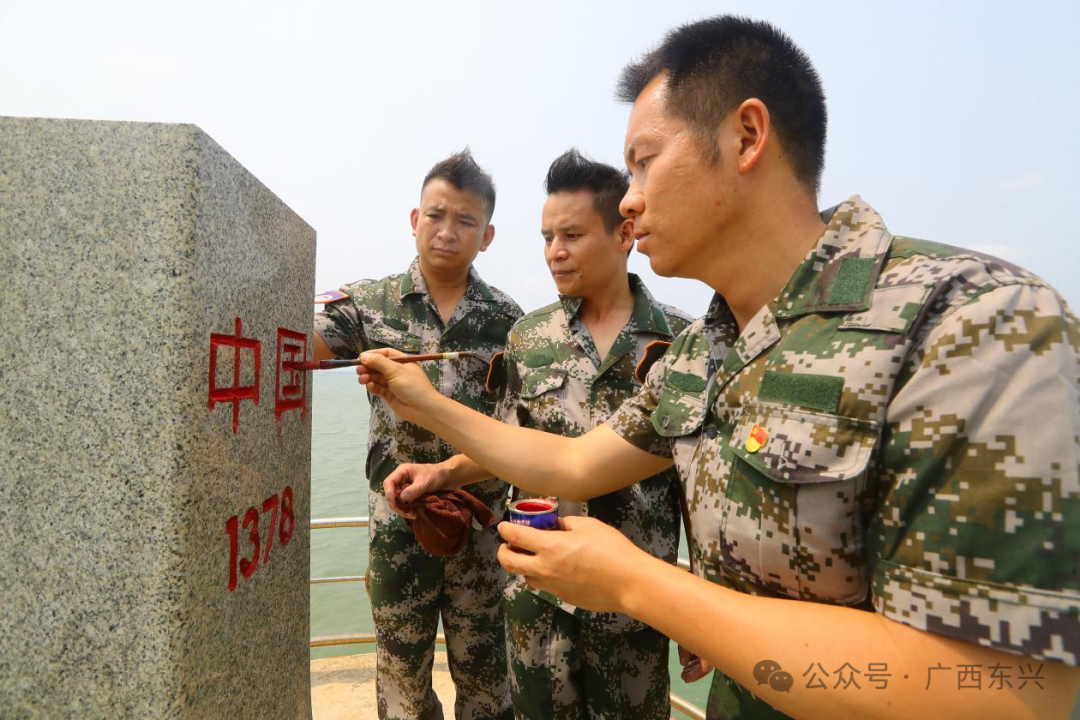 苏世艺（右一）正在为界碑描红。图片由受访者提供