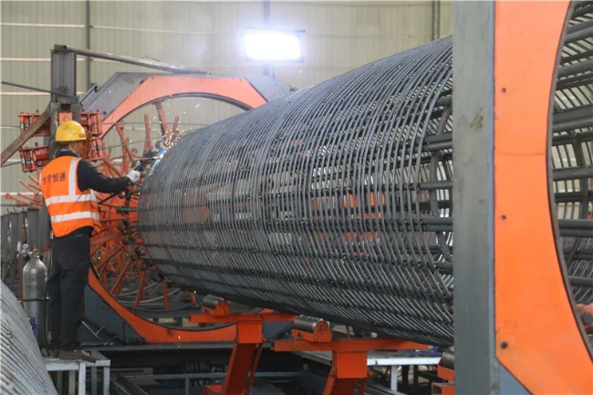 工人使用拱焊机焊接墩柱钢筋笼