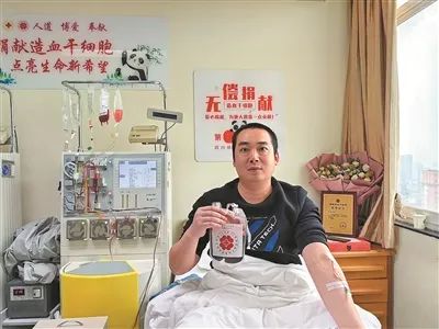 李张采集造血干细胞混悬液后，在病床上留影。