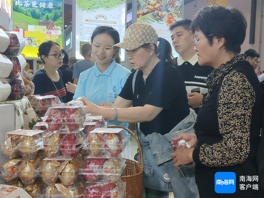 　　万宁市禄禄红食品有限责任公司展台 消费者被烤海鸭蛋吸引。记者 张野 摄