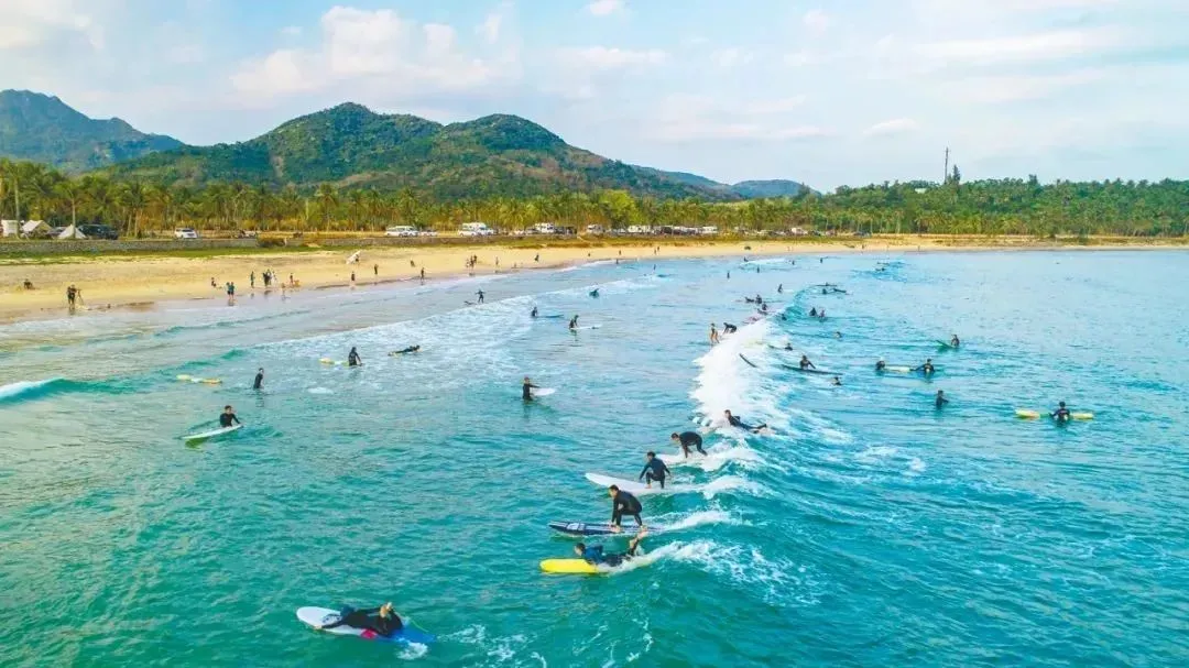 ▲ 游客在万宁市日月湾的浪尖跳跃、冲刺，展示矫健身姿，享受假日时光。海南日报记者 袁琛 摄