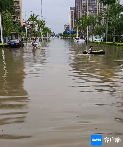 人民路上的积水点，小孩在路面上划船。记者 苏桂除 摄