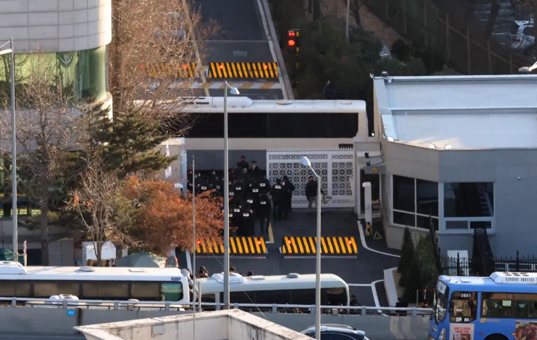 1月3日上昼,韩国高等公职东说念主员违警访问处职责主说念主员和警方在首尔龙山区汉南洞的总统官邸大门外恭候参加。新华社/纽西斯通信社