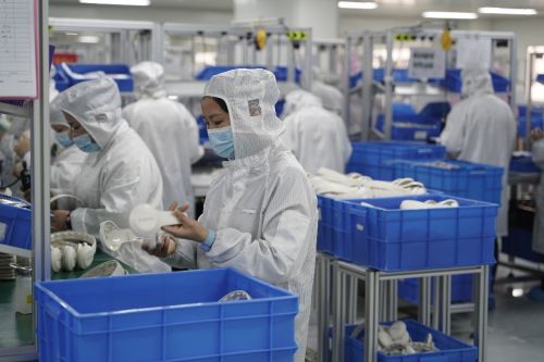 ▲无尘车间内，小白熊的工作人员正对产品进行质检。（摄影 胡弘彪）