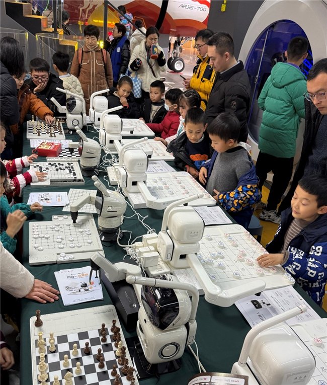 (现场观众踊跃体验元萝卜AI下棋机器人)