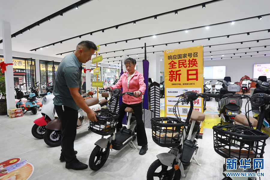 在云南省腾冲市一新能源电动自行车店，顾客体验“以旧换新”的新能源电动自行车。新华网发（赵辉 摄）