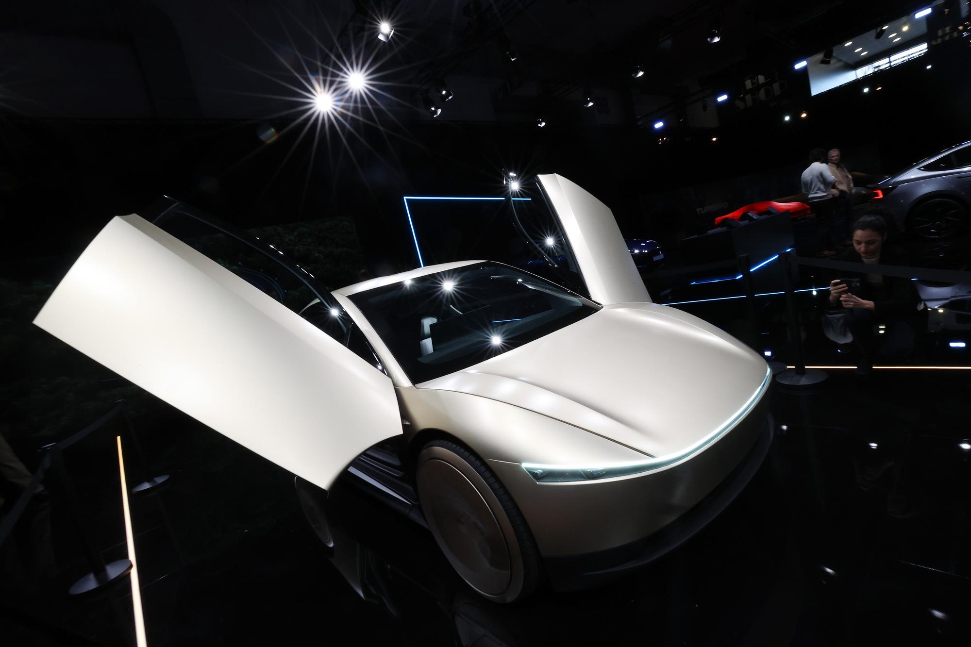 1月10日，在比利时布鲁塞尔举办的2025布鲁塞尔车展上，一名女子拍摄特斯拉Cybercab汽车。新华社记者赵丁喆摄