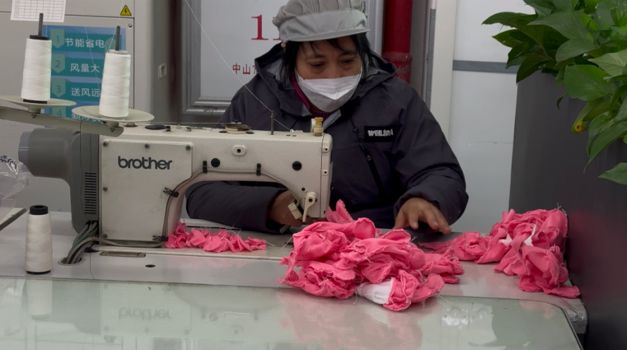 图说：工人正在拼接“乐融融”毛绒玩具缝片