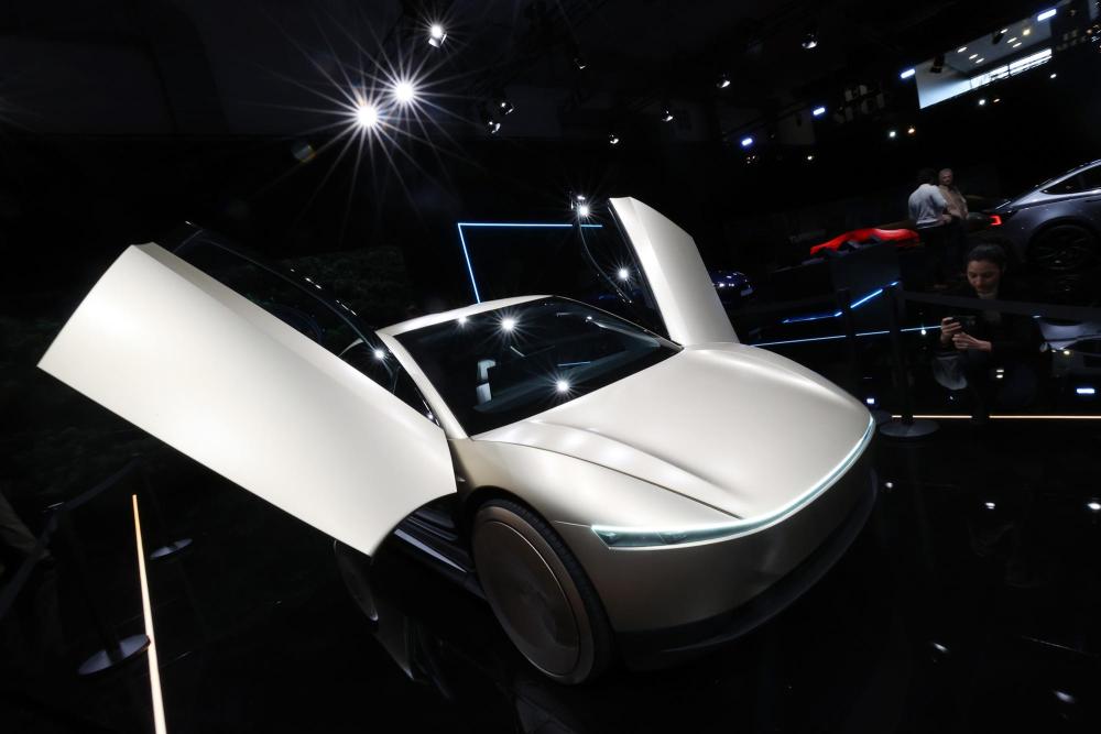 1月10日，在比利时布鲁塞尔举办的2025布鲁塞尔车展上，一名女子拍摄特斯拉Cybercab汽车。新华社记者赵丁喆摄