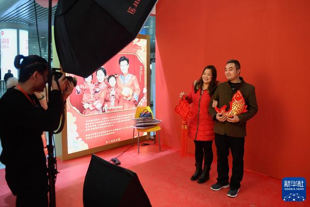 2019年1月21日，一对夫妻在杭州火车东站接受“幸福照相馆”的免费合影服务。 新华社记者 黄宗治 摄